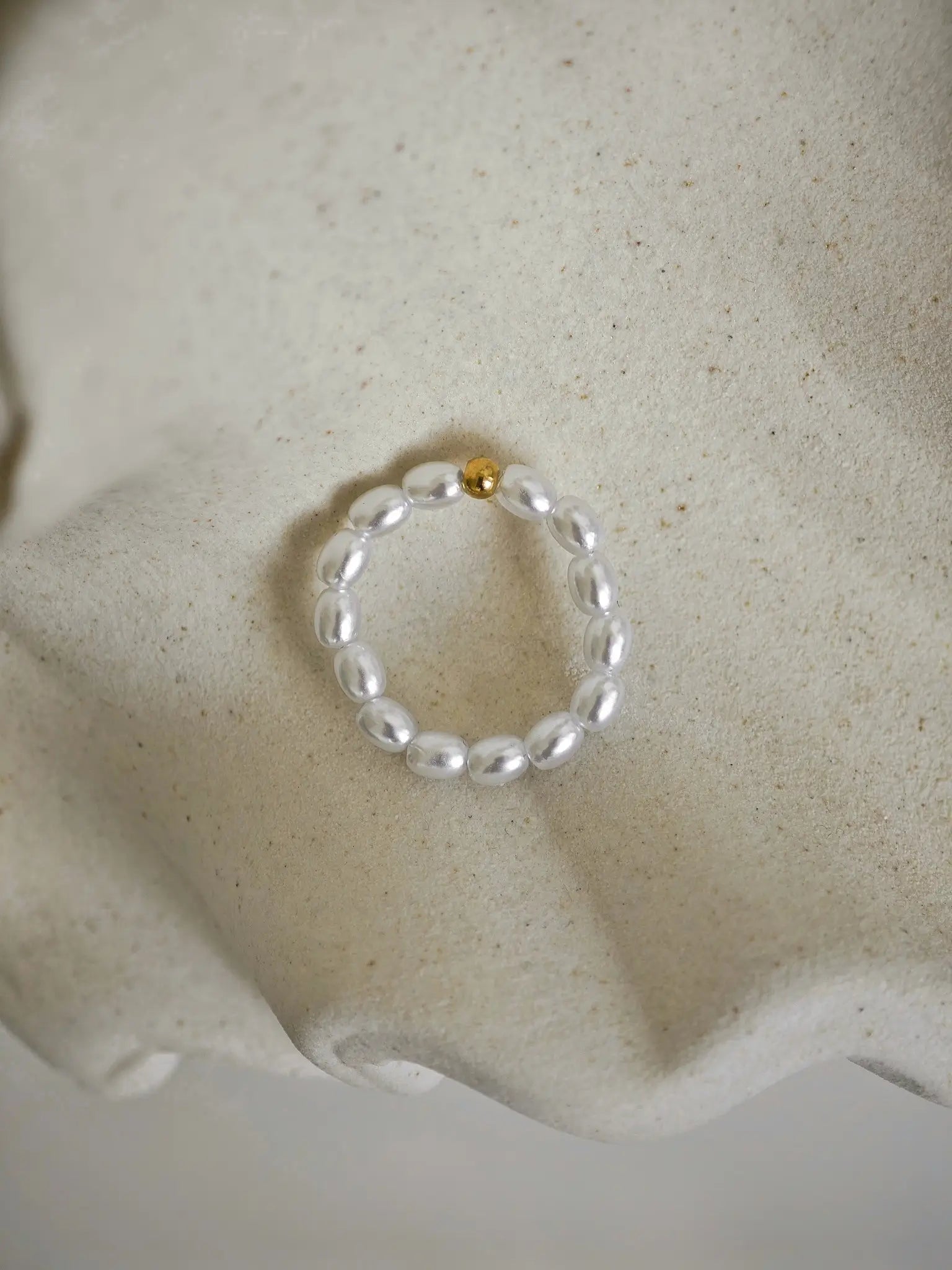 Perlenring mit Edelstahl-Kugel in der Mitte, umgeben von zarten Mini-Perlen