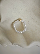 Perlenring mit Edelstahl-Kugel in der Mitte, umgeben von zarten Mini-Perlen