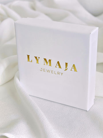 Schmuckbox in weiss mit einem gold Logo von Lymaja Jewelry für Halsketten Ringe und Ohrringe 