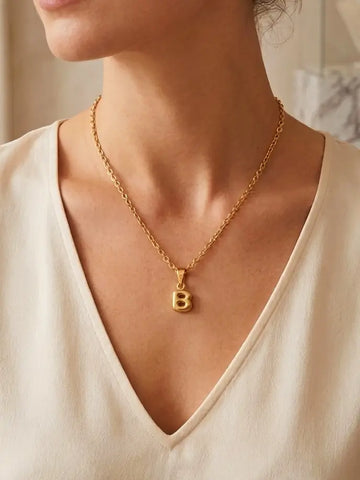 Moderne Frau trägt die goldene Bubble Letter Charm Halskette personalisiert mit ihrem Initial