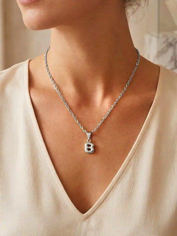 Moderne Frau trägt die silberne Bubble Letter Charm Halskette personalisiert mit ihrem Initial