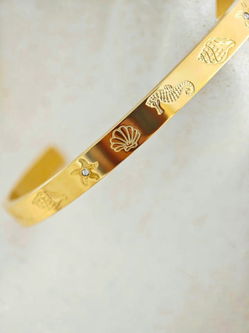 Goldener Armreif mit graviertem Seestern, Muschel, Seepferdchen und kleinen Zirkonia-Steinen