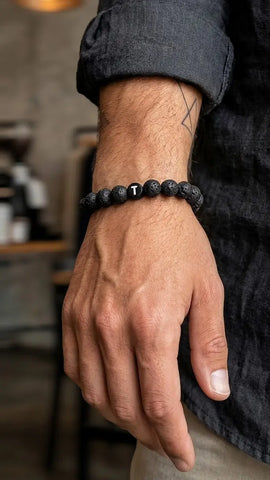 Partnerarmband mit Lava Perlen in schwarz und einem Wunschbuchstaben personalisiert und getragen von einem Man