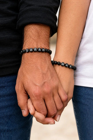 Namensarmband Set mit Wunschnamen aus Naturstein-Onyxperlen, getragen am Handgelenk eines Paares Hand in Hand