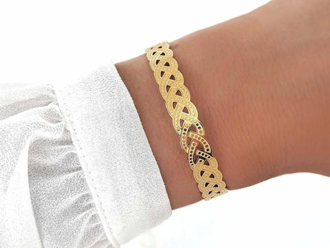 Geflochtener goldener Ayasha Armreif aus 18k vergoldetem Edelstahl mit filigranem Cut-Out-Muster im Infinity-Stil von LYMAJA
